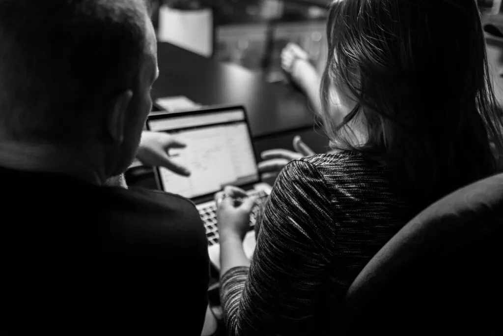 excite media employees discussing SEO in front of a laptop