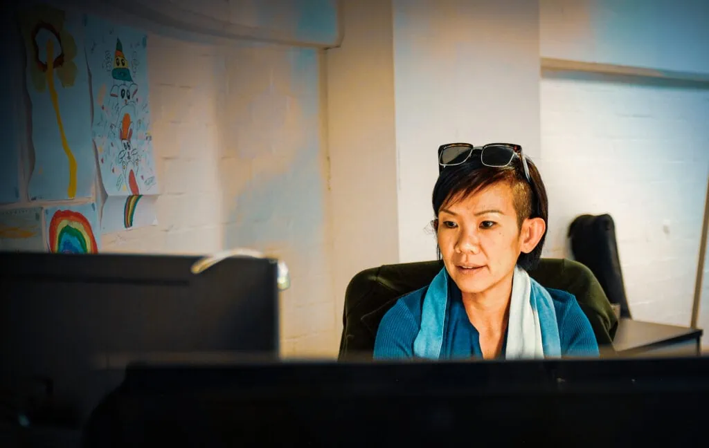 woman with glasses on her hair in front of her computer