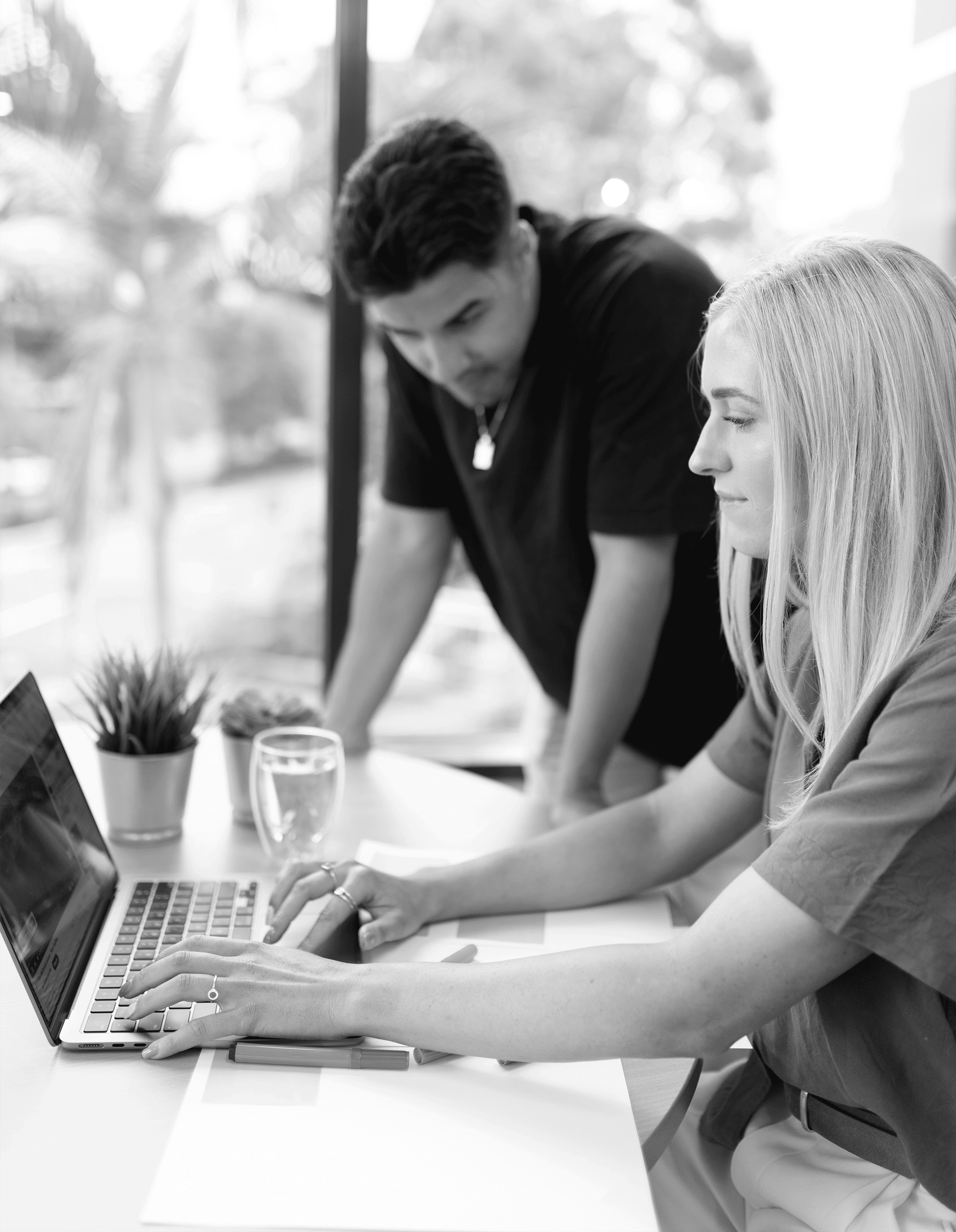 Georgia and Karlos from our website production team sitting at a laptop together.