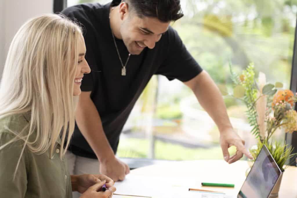Web designers, Karlos and Georgia looking at a laptop together