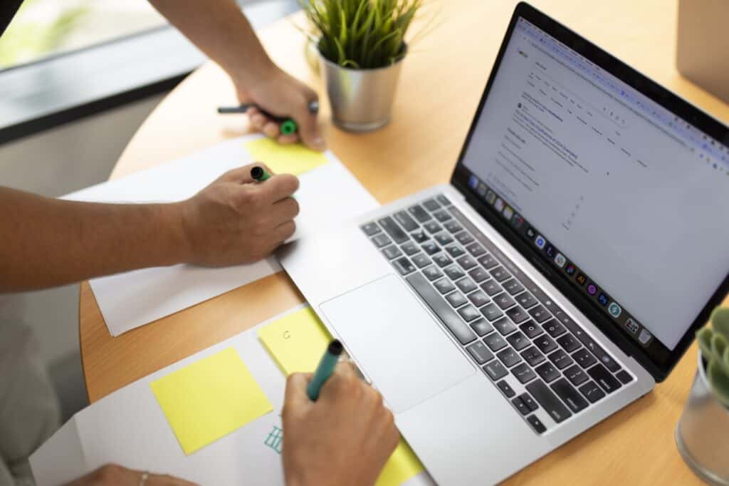 Two web designers leaning over a laptop on a desk