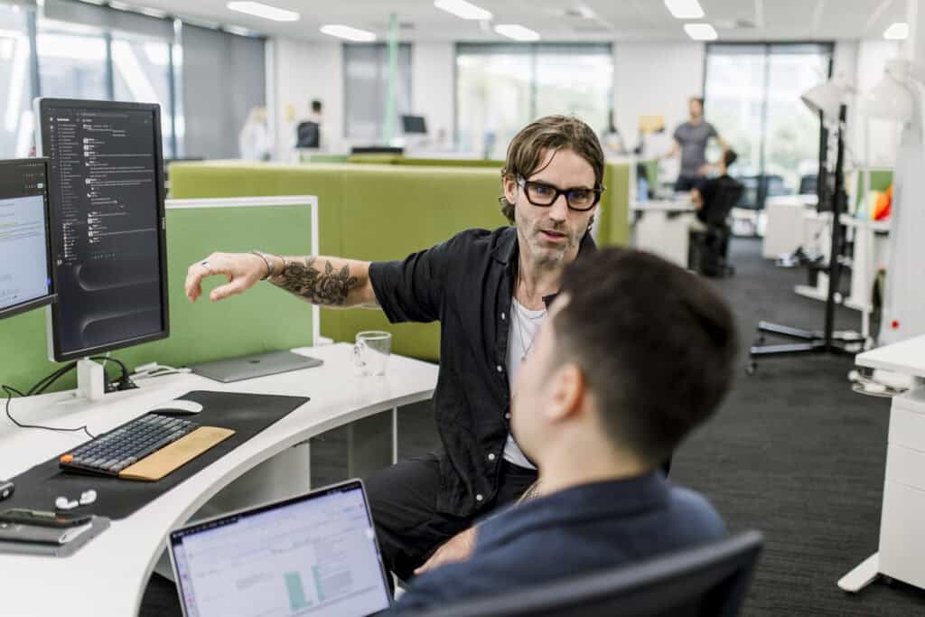 Nick Gregory discussing work with colleague in office