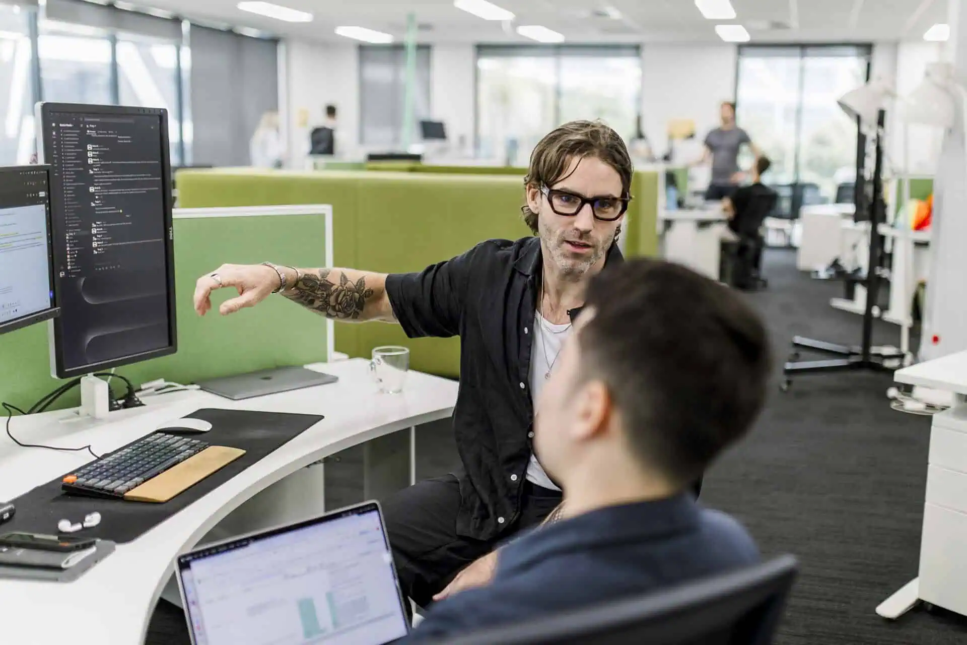 Nick Gregory discussing work with colleague in office