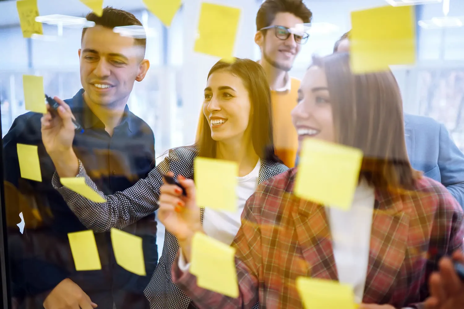 group of workers writing on the sticky notes